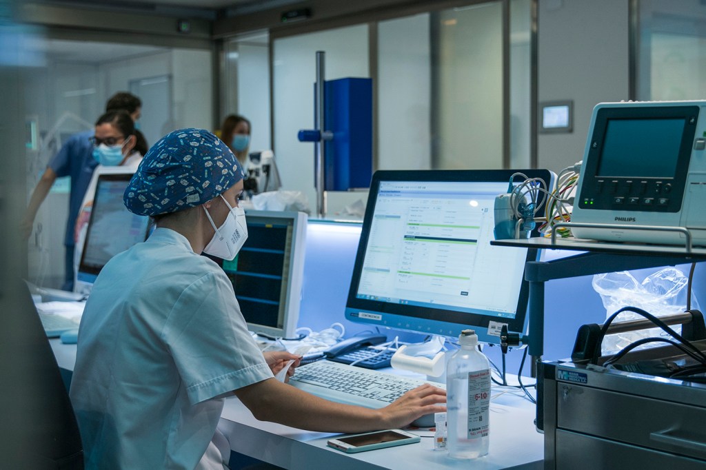 A nurse works in the ICU at a computer